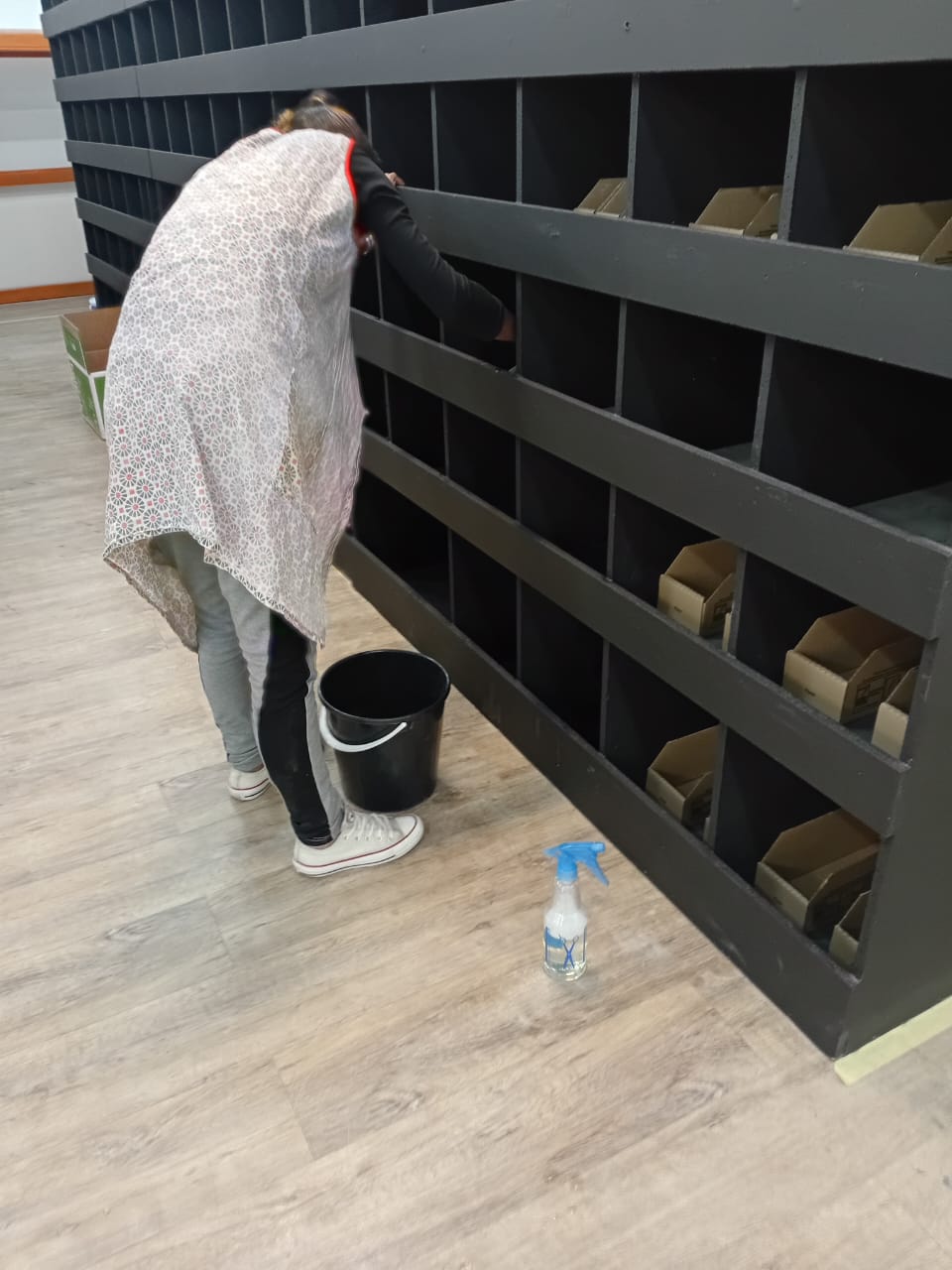Worker meticulously cleaning shelves at a business